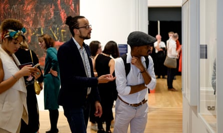 Visitors look at Zanele Muholi’s photography at the Walker gallery’s Coming Out exhibition.