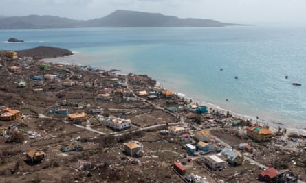 Drone shot of debris and damaged houses near coast