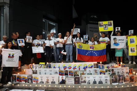 A group of people attend a vigil holding signs
