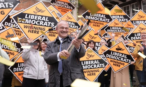 Liberal Democrat leader Ed Davey holding party signs with supporters