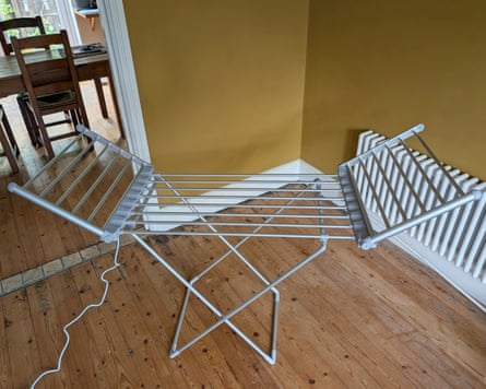 A Beldray winged heated airer stands open on a wooden floor near a radiator