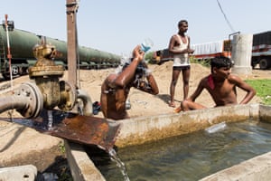Men wash in a trough at Latur train station