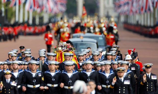 Royal Navy sailors walk ahead and behind the coffin of Queen Elizabeth II as it travels from Westminster Abbey to Wellington Arch in London