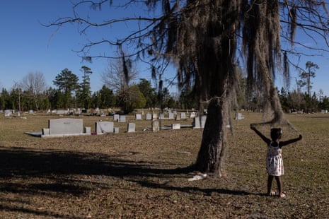 A young girl plays with spanish moss in a cemetery