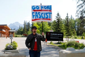 A man holding a sign reading go home fascist