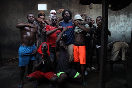 A group of young African men pose, making rappers' 'gun fingers' hand gestures