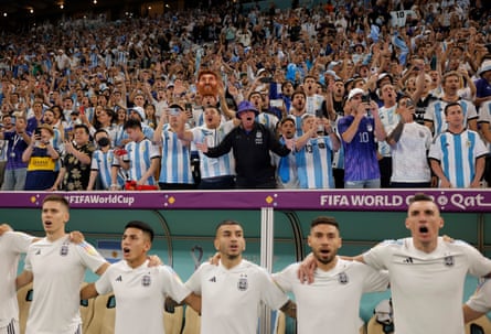 Argentina fans and players on the bench sing their national anthem before the quarter-final.