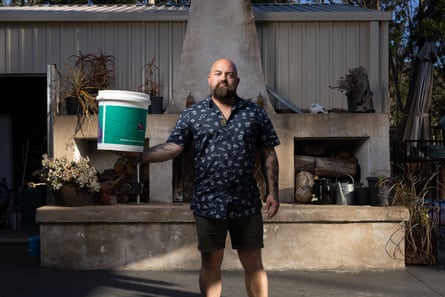 Hohnen in his back garden holding a large plastic bucket
