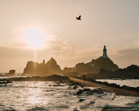 A lighthouse silhouetted at sunset