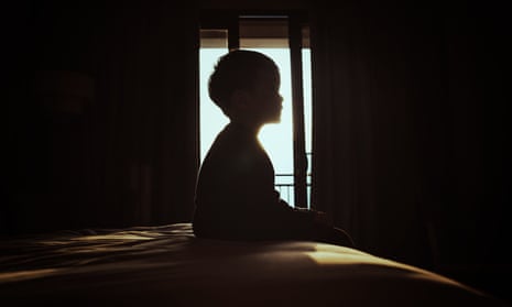 Silhouette of child sitting on bed