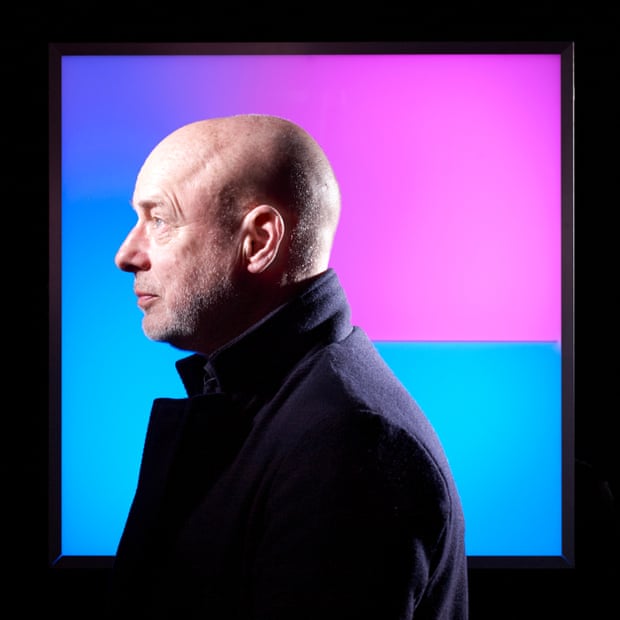Brian Eno, in profile, wearing a jacket with a turned-up collar