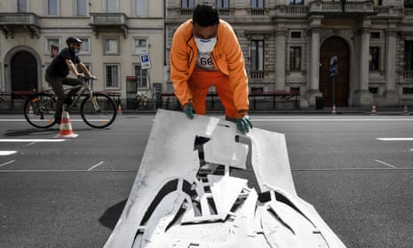 A worker paints signs for a new cycle path in central Milan.