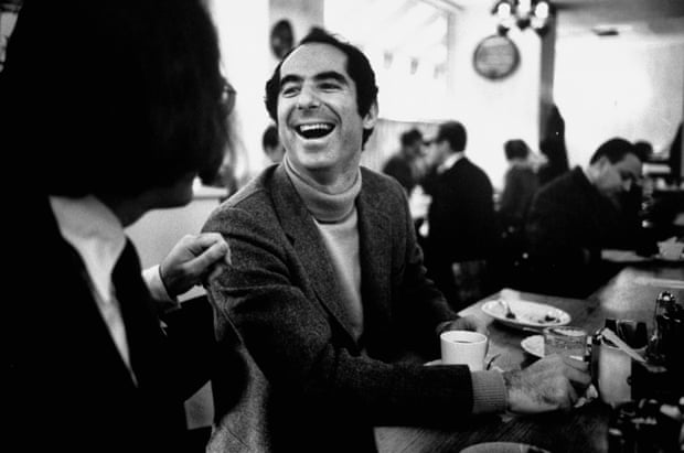 Philip Roth sitting at lunch counter in Newark, New Jersey in 1968, talking to a customer.