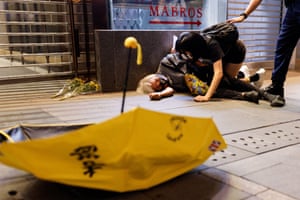 A protester lies on the ground after being pushed during a protest in Hong Kong over Covid-19 restrictions in mainland China