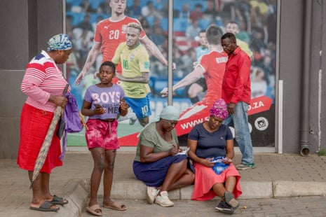 Customers place their bets outside a sports betting shop in the Soweto township of Johannesburg, South Africa, December 2022. 