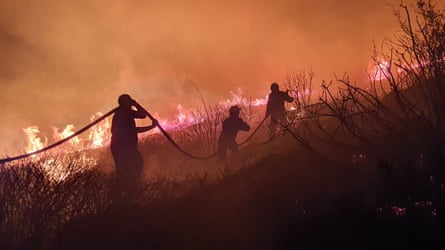 A volunteer with the Greek fire service tackles a wildfire in near Athens.