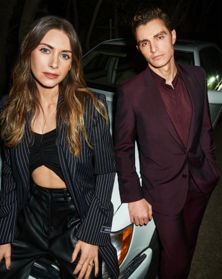 They lean against a white sports car
