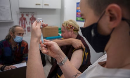 Sive O'Regan gives homeless man Sam French a Covid-19 vaccine while outreach specialist Adrian Bean Noctor records details of the treatment given throughout the day
