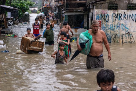 Residents evacuate to higher grounds with their belongings in Barangay Sta Ana, San Mateo, Rizal, the Philippines.