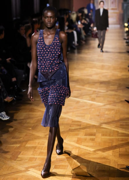 A model wearing a satin-looking purple and pink dress.