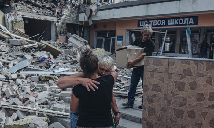 Two teachers hug when they see their school shelled by the Russian army in Bakhmut, Ukraine, 24 July.