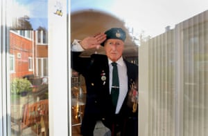 George Bradford, 90, a former Royal Marine, stands behind a window at the RBLI home in Aylesford, Kent