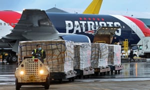 Workers unload a jet used by the New England Patriots after it landed at Logan Airport from Shenzhen, China with a shipment of over one million N95 masks.