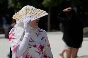 Milan, ItalyA tourist shields from the sun in Milan