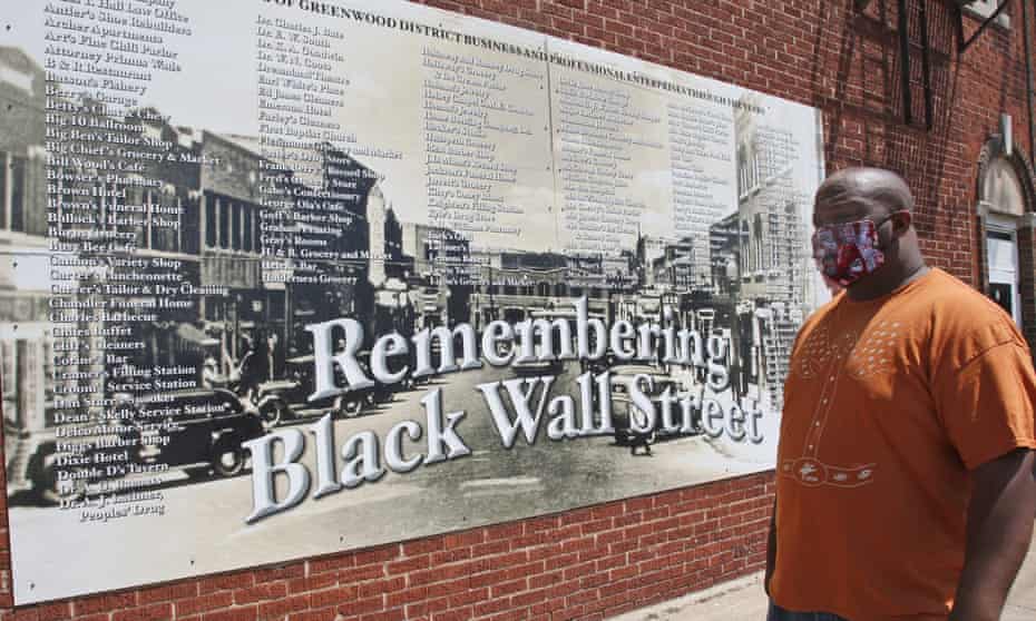 Freeman Culver stands in front of a mural listing the names of businesses destroyed during the Tulsa race massacre in Tulsa, Oklahoma.