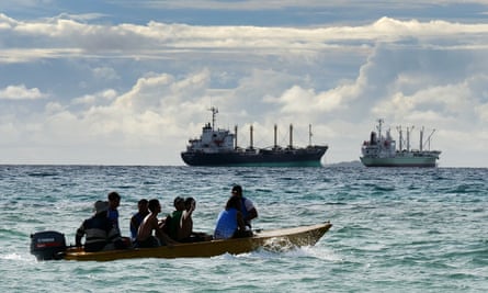 Local fishermen in Tuvalu with a foreign fishing vessel in the background