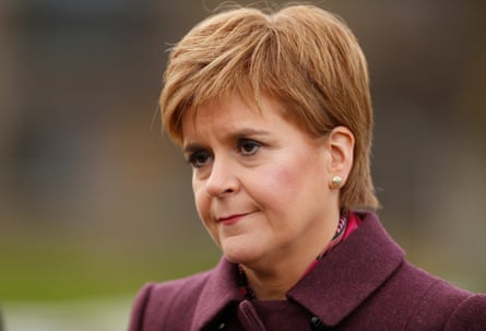Nicola Sturgeon in purple coat frowning and smiling at the same time
