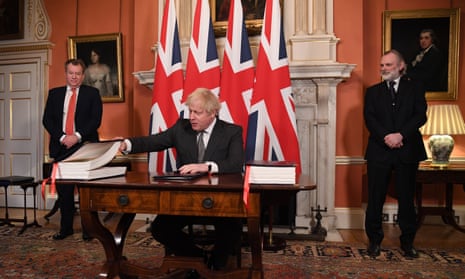 Boris Johnson signing the trade deal, with David Frost (left), the UK’s chief negotiator, and Sir Tim Barrow, its ambassador to the UK (right) looking on.