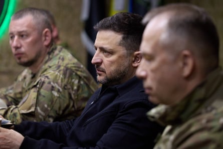 Volodymyr Zelenskyy flanked by Ukraine soldiers in uniform