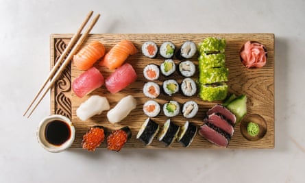 Nigiri and sushi rolls presented on a wooden serving board.