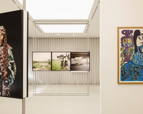 A light-filled white room hung with paintings and photographs.
