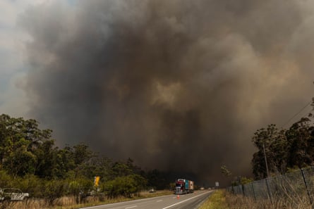 Smoke from a bushfire disrupts traffic on the Pacific Highway near the town of Nerong south of Bulahdelah, NSW, Australia