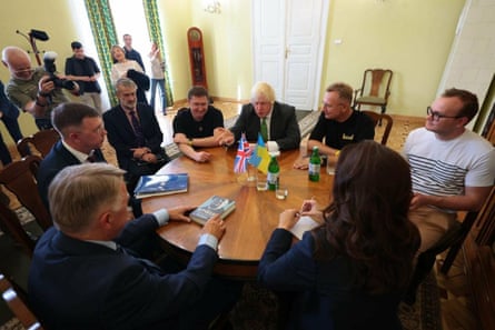 Boris Johnson sits around a table in Ukraine with seven other people including Christopher Harborne