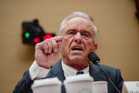 A man speaks angrily in to a microphone while pointing his finger