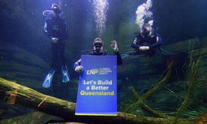 Tim Nicholls (centre) scuba-dives in a fish tank at the Cairns Aquarium.
