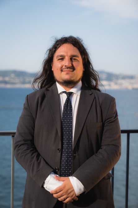 A portrait of Josi Gerardo Della Ragione, wearing white shirt, a dark tie with white spots and a brown suit.