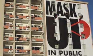 A billboard is installed on an apartment building encouraging people to wear face masks in Cape Town South Africa, Saturday, May 16, 2020, marking day 51 of a strict government lockdown in a bid to prevent the spread of coronavirus.