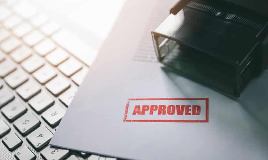 document with approved stamp on computer keyboard