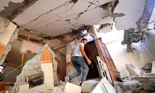 A Palestinian man inspects his badly damaged home, following Israeli air strikes in Gaza City.