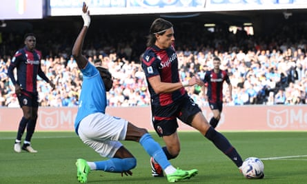 Bologna's Riccardo Calafiori is challenged by Napoli's Victor Osimhen