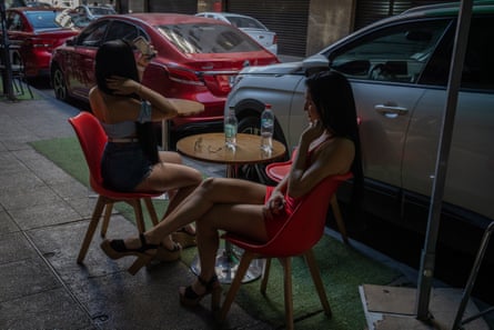 Two waitresses enjoy their break from work at the café con piernas where they are employed in Santiago, Chile.