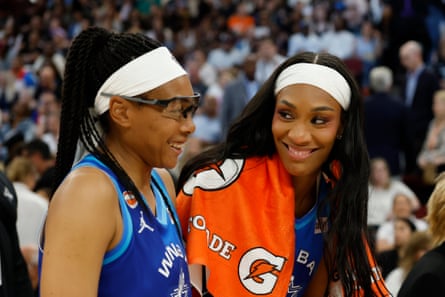 Two female hoops players smile at each other.