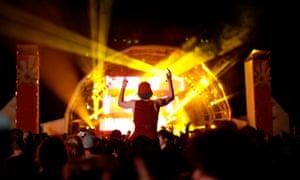 A young guy with a cap on sits on his friend’s shoulders with his hands in the air whilst watching Skream perform at Outlook Festival 2011 in Croatia.