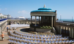 Striped deck-chairs in a semi circle around the bandstand on the promenade at Eastbourne in Sussex