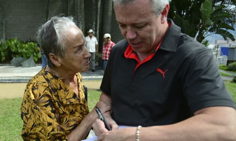 John Jairo Velasquez, A.K.A “Popeye”, signs a bank note for a woman beside the tomb of Colombian drug lord Pablo Escobar.
