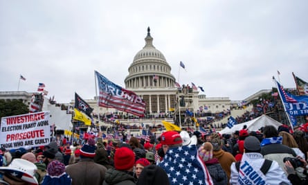 Men and women in crowd hold flags outside US Capitol